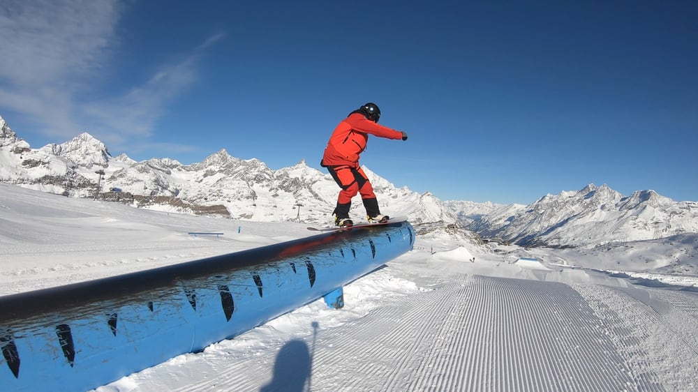 A skier on a rail in the snow park